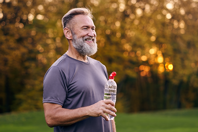 the old man holding bottle of a water